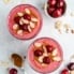 top-down view of two cherry smoothies topped with almonds and frozen cherries