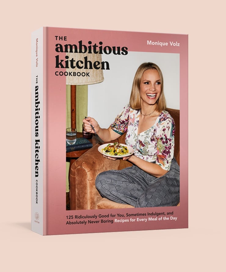 the cover of the ambitious kitchen cookbook on a pink background