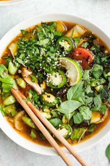 asian chicken soup in a bowl with chopsticks