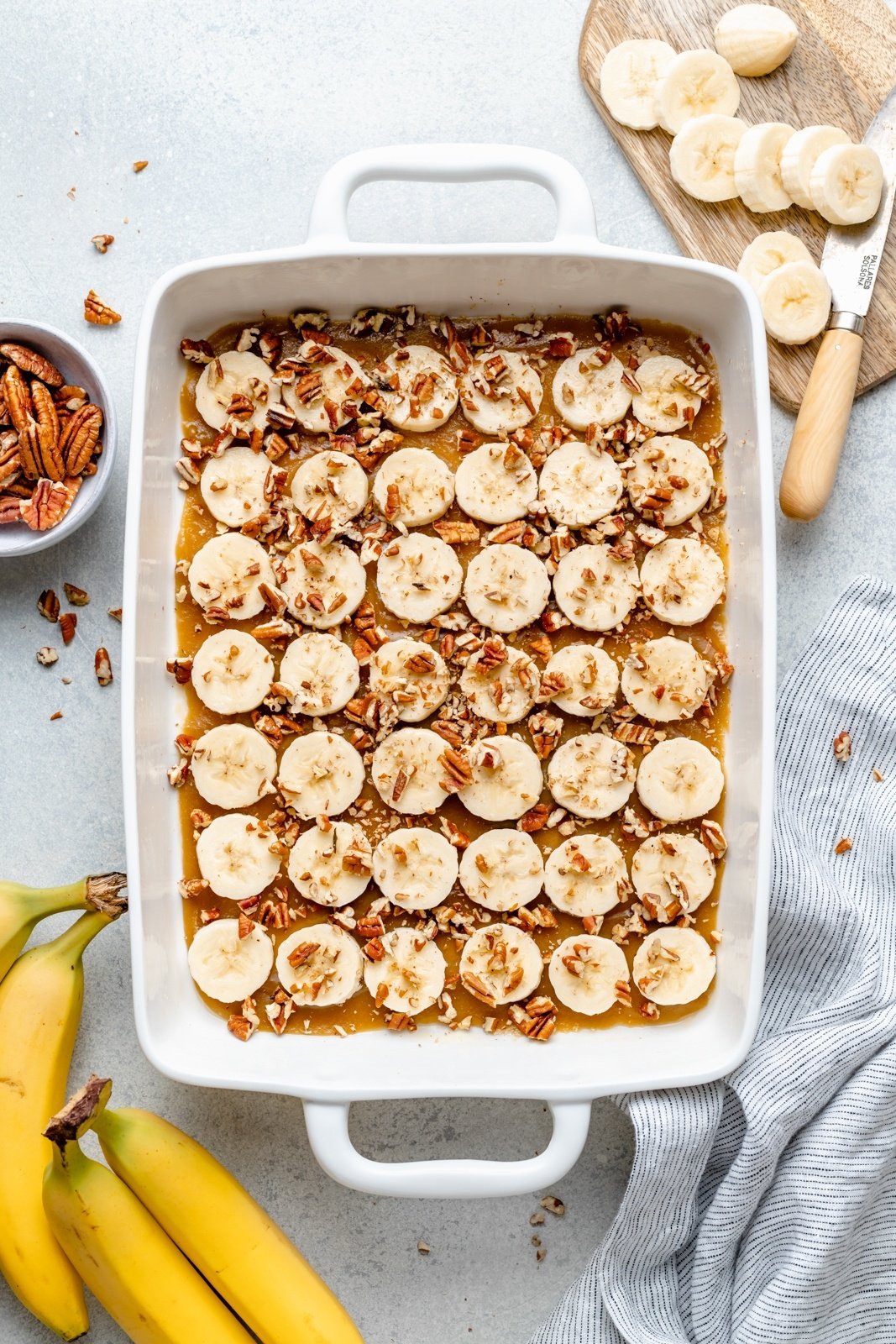 layering a banana french toast bake in a pan