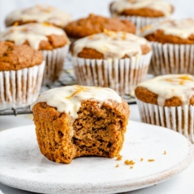 orange pumpkin muffin on a plate with a bite taken out