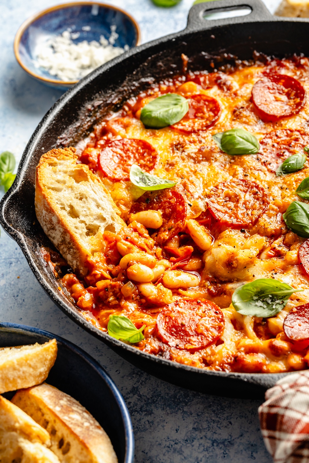 crostini dipped into a skillet with pepperoni white bean bake