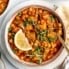 lentil Moroccan stew in a bowl with a lemon wedge