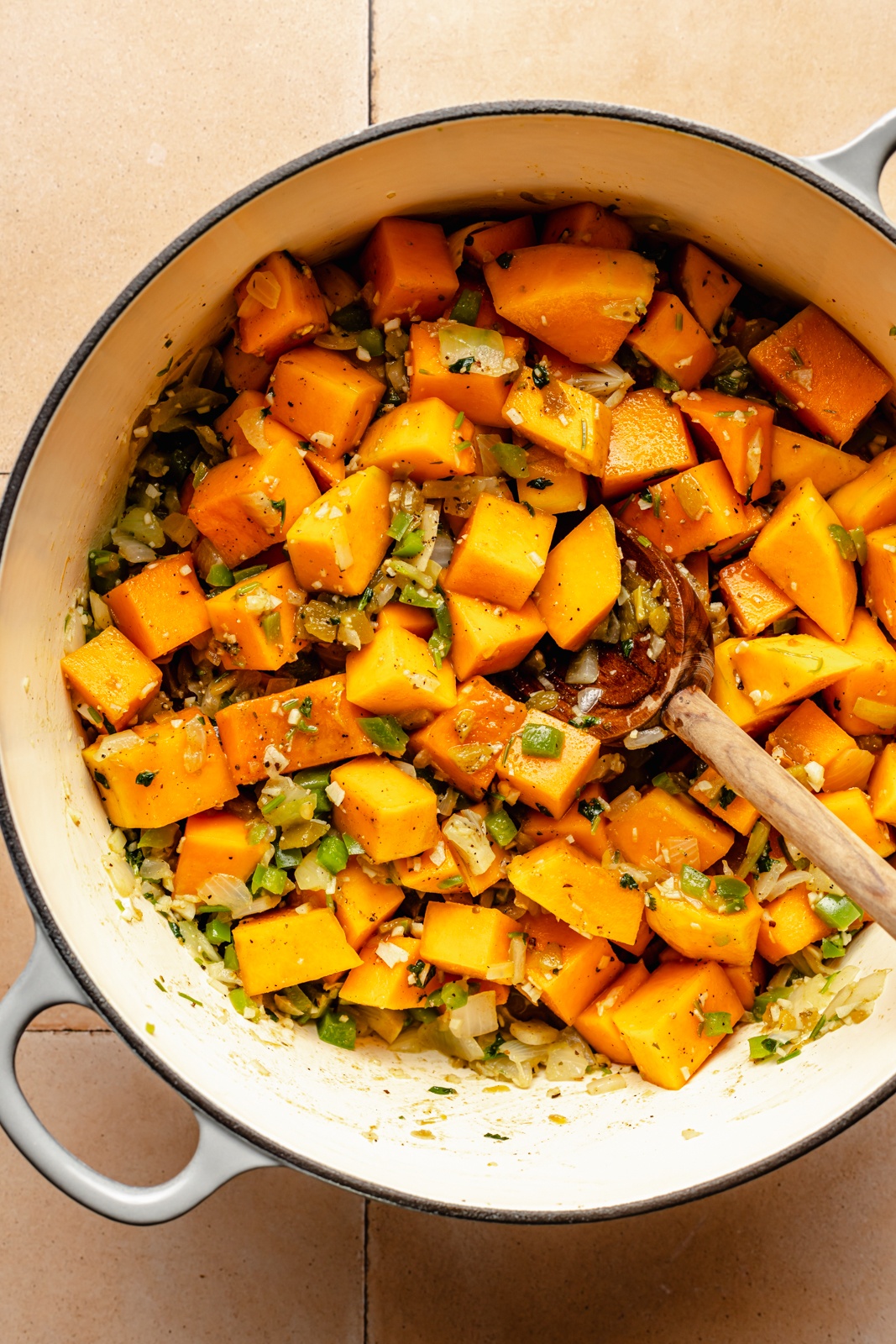 cooking butternut squash in a pot to make green chile chicken soup