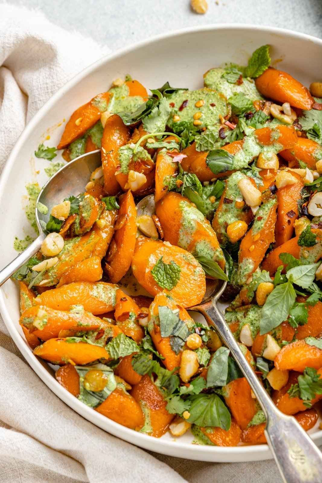 caramelized garlic carrots in a bowl with jalapeño cilantro sauce