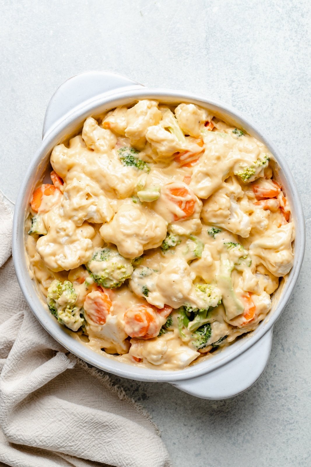 unbaked broccoli cheddar cauliflower gratin in a baking dish