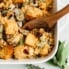 cornbread stuffing in a baking dish with a wooden spoon