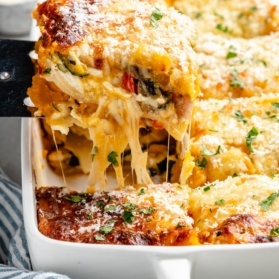 pulling up a slice of butternut squash lasagna from a pan