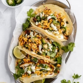 three healthy street corn chicken tacos in a basket