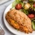 jalapeño popper stuffed chicken breast on a plate with a salad