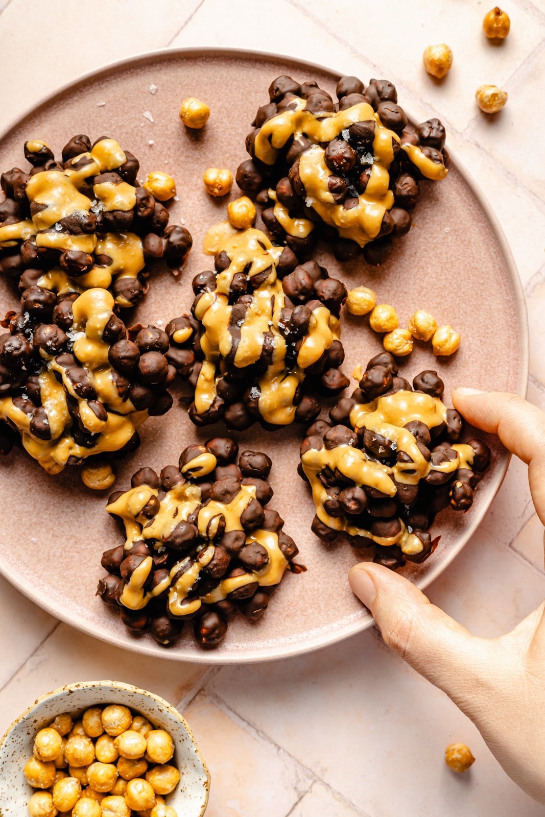 no bake chocolate chickpea clusters drizzled with peanut butter on a plate