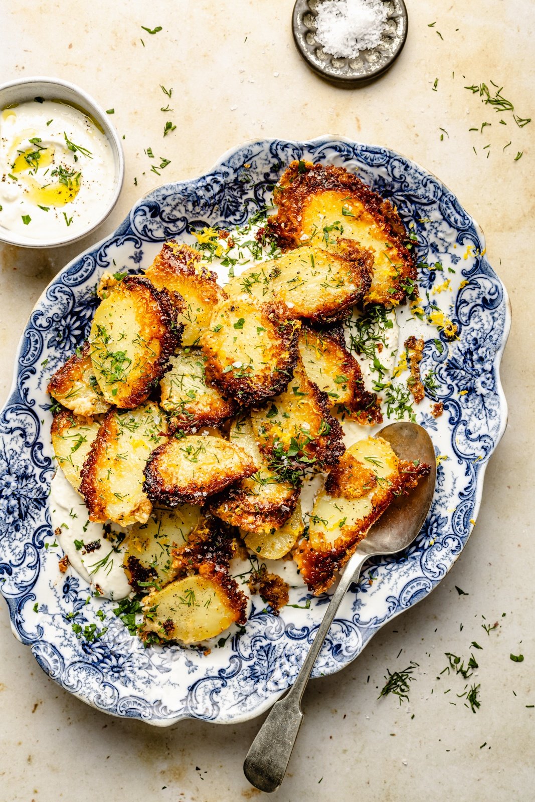 parmesan potatoes on top of garlic feta dip in a serving bowl