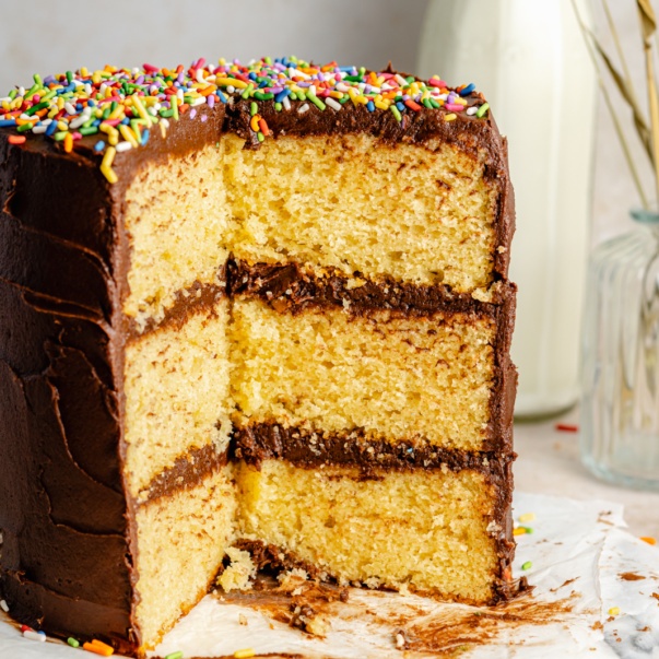 yellow cake with chocolate buttercream frosting with slices taken out