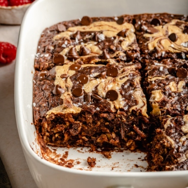 chocolate peanut butter baked oatmeal in a baking dish with a slice cut out