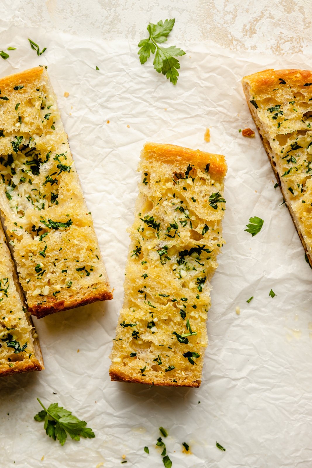 sliced of homemade garlic bread on parchment paper