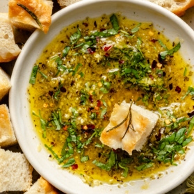 olive oil dip in a bowl with a piece of bread