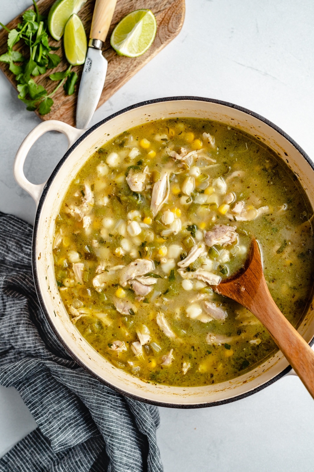 green chicken pozole recipe in a pot with a wooden spoon