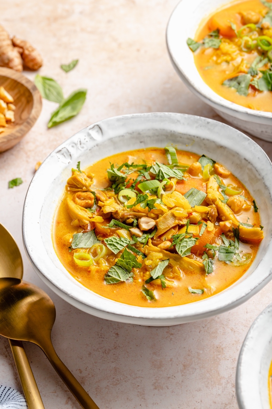 garlic ginger chicken soup in a bowl topped with herbs