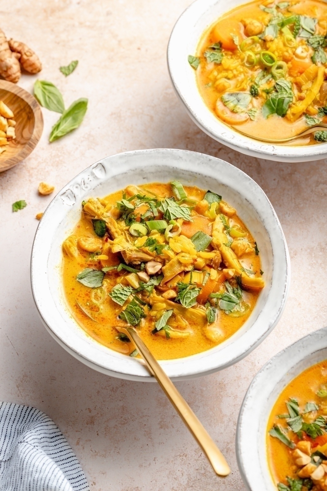 ginger chicken and rice soup in a bowl topped with herbs