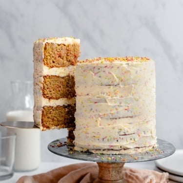 pulling a slice of healthy birthday cake out from a cake stand