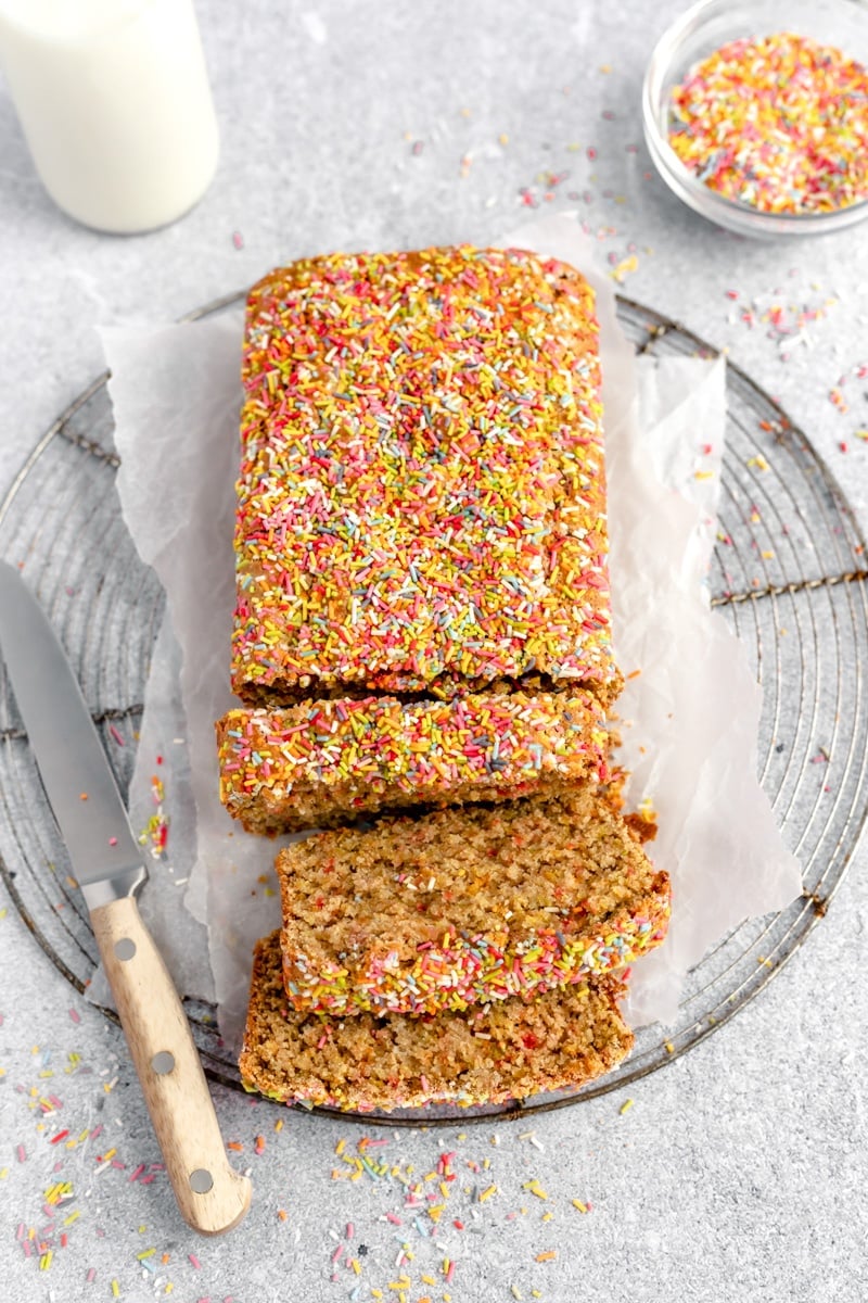 gluten free birthday cake loaf cut into slices on a wire rack