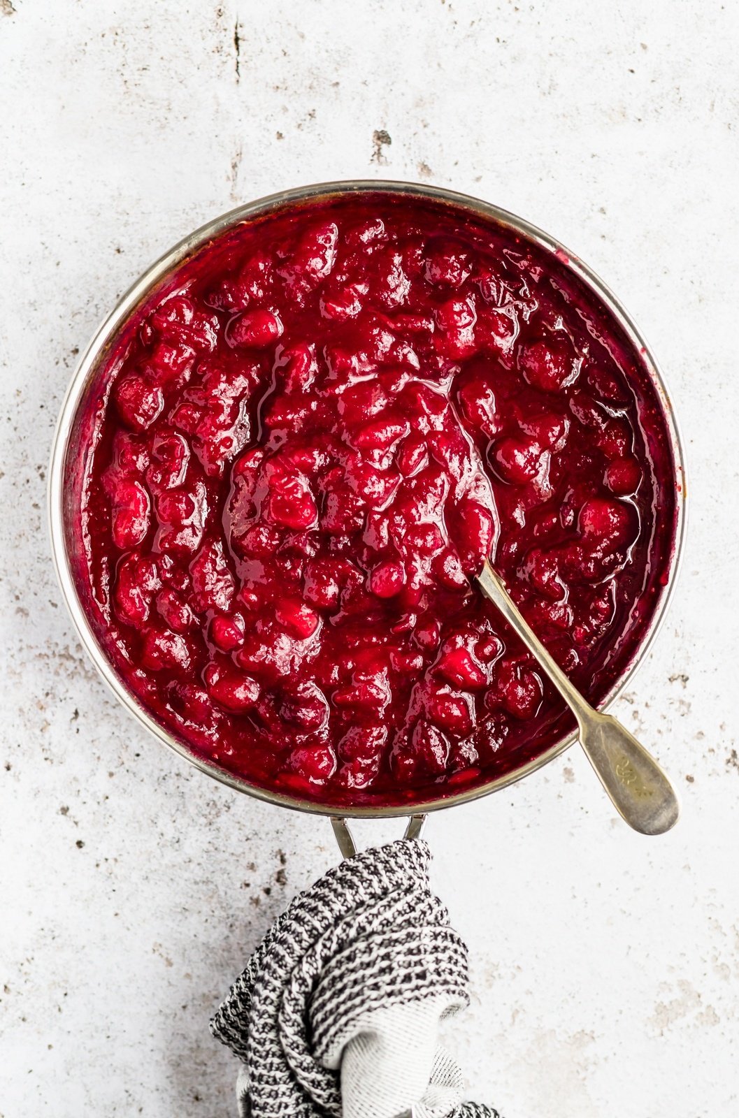 healthy orange cranberry sauce in a pot with a spoon