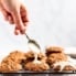 maple pecan oatmeal cookies being topped with a salted maple icing