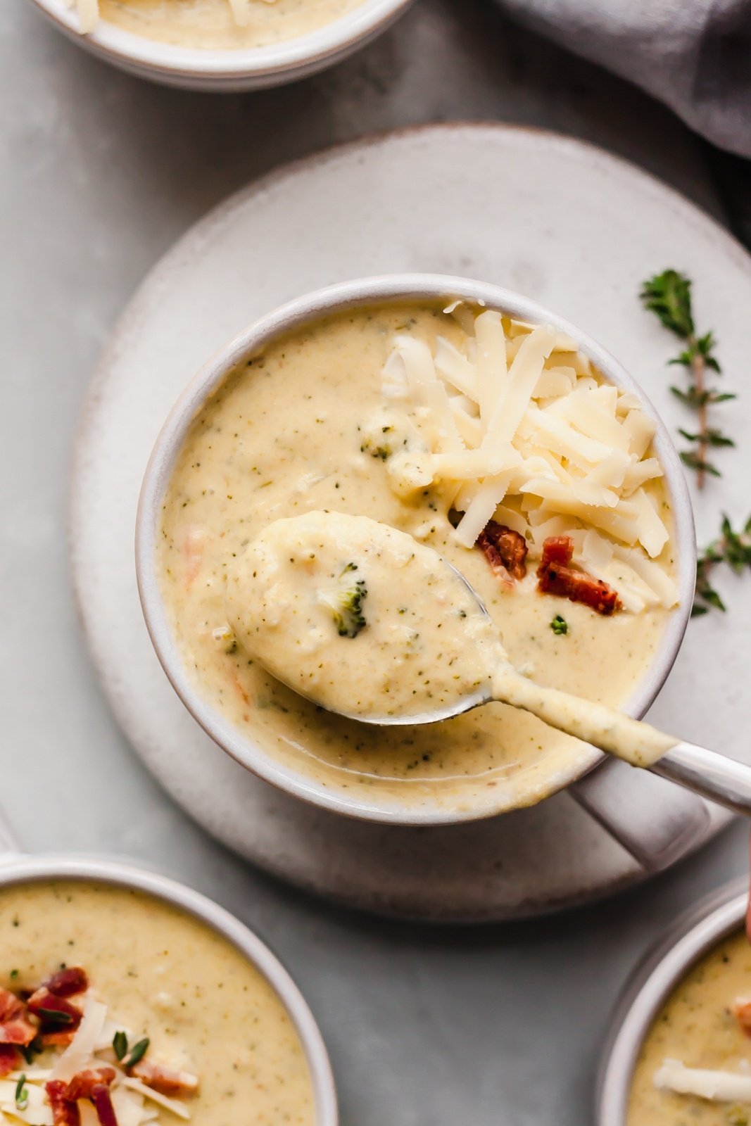 a spoon pulling up broccoli cauliflower soup from the bowl