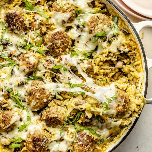 pesto orzo with chicken meatballs in a skillet