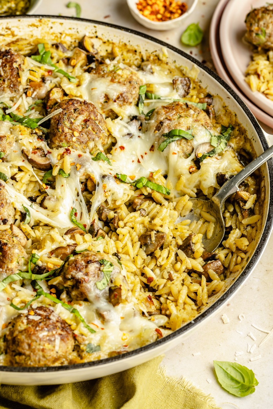 pesto orzo with chicken meatballs in a skillet