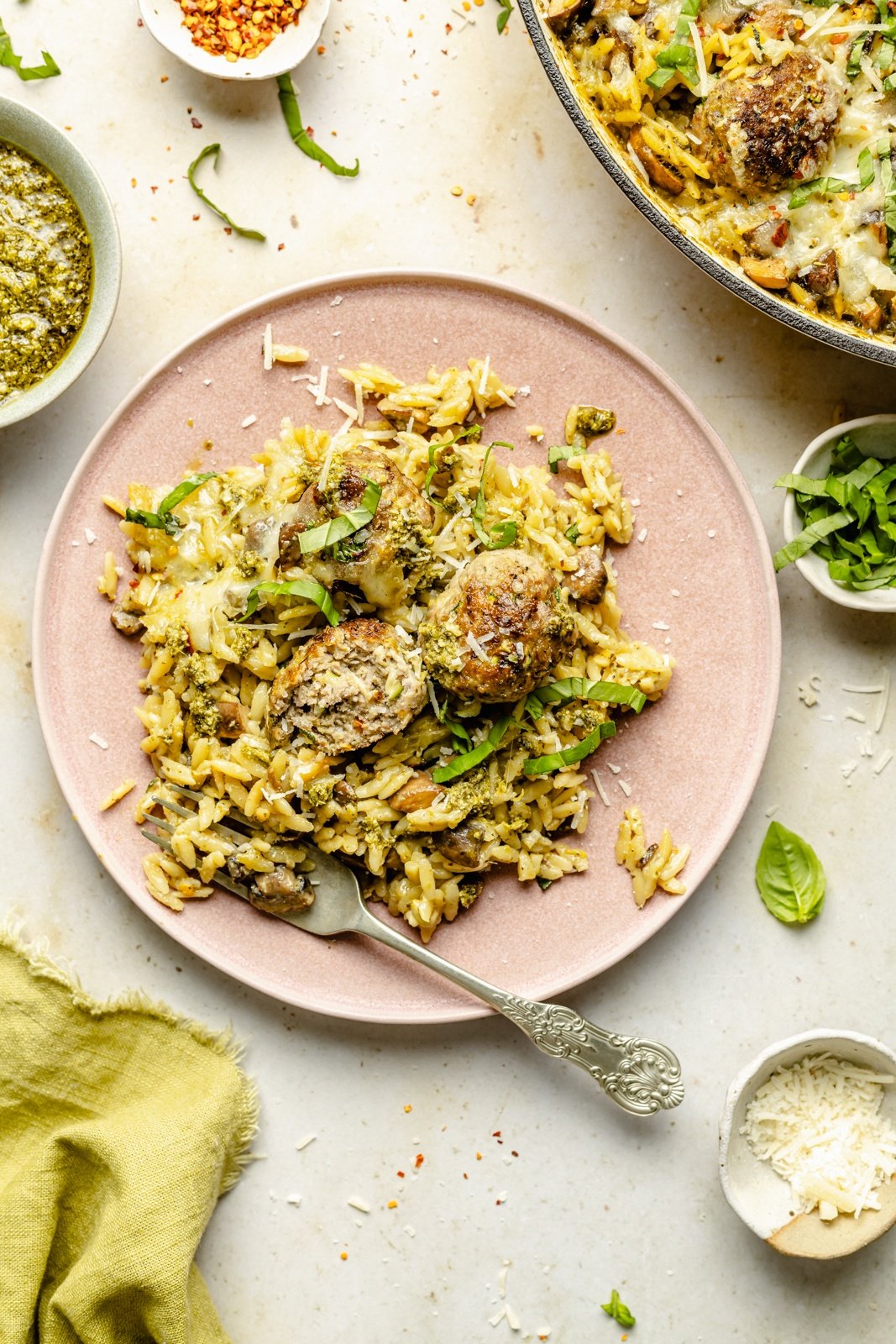 baked pesto orzo with chicken meatballs on a plate