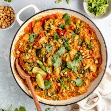 Thai peanut chicken couscous in a pan with a wooden spoon