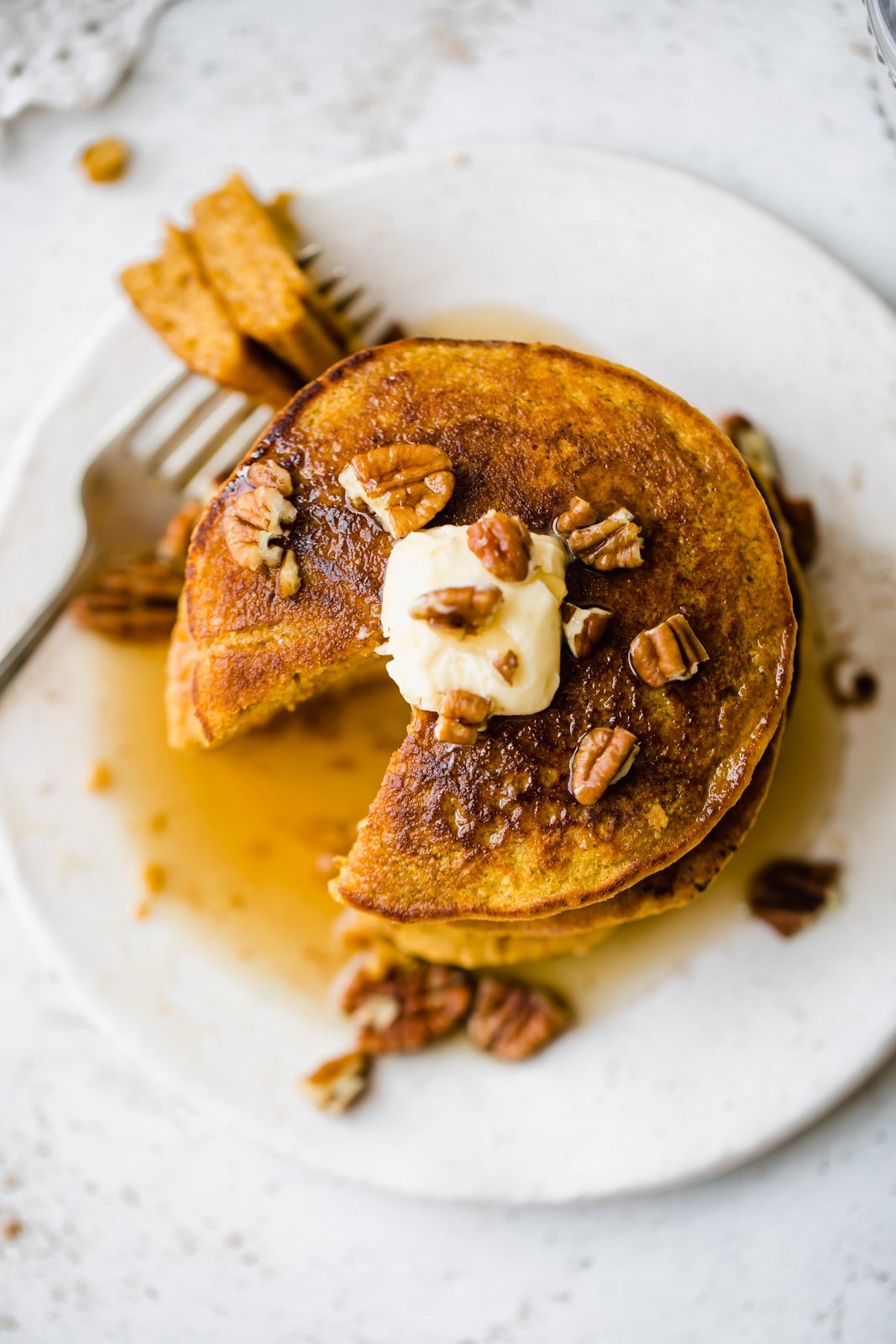 overhead shot of gluten free pumpkin pancakes with a bite taken out