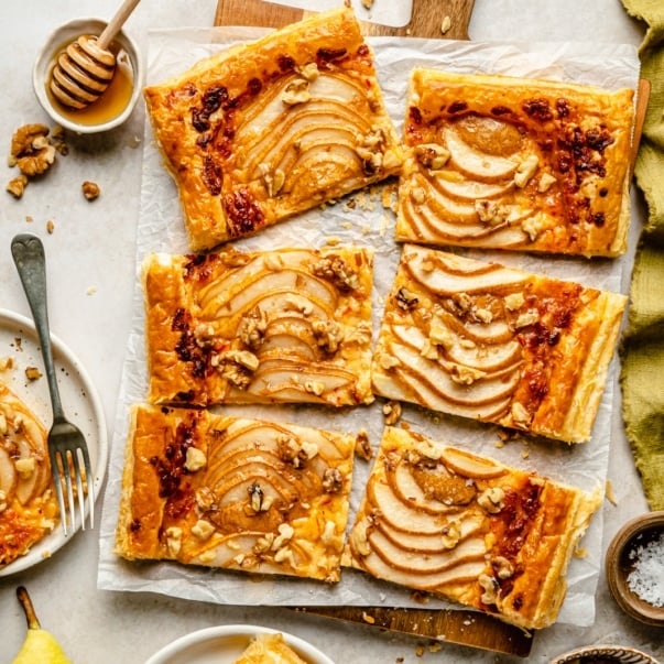 pear puff pastry tart sliced on parchment paper