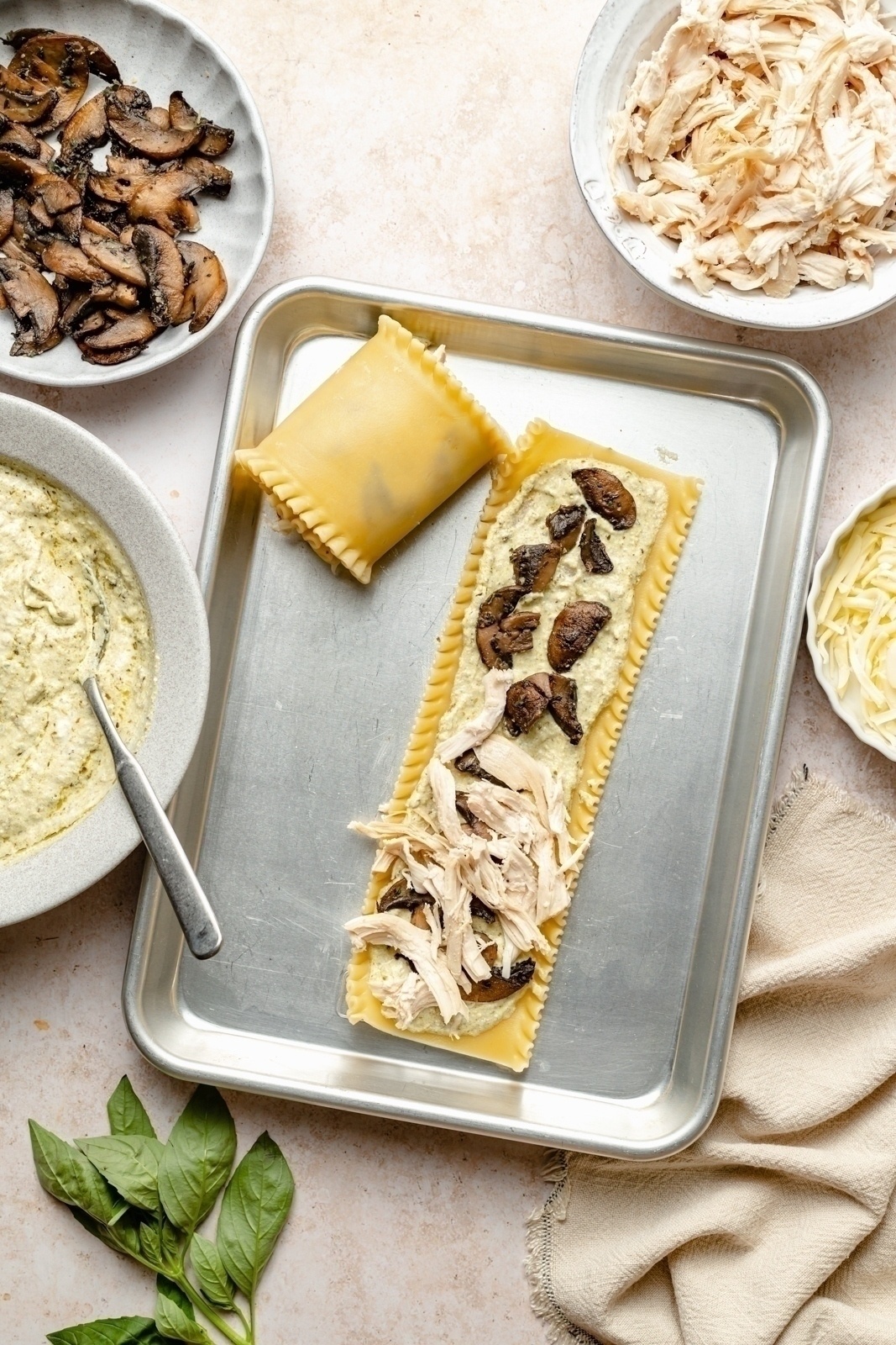 assembling mushroom chicken lasagna roll ups on a pan