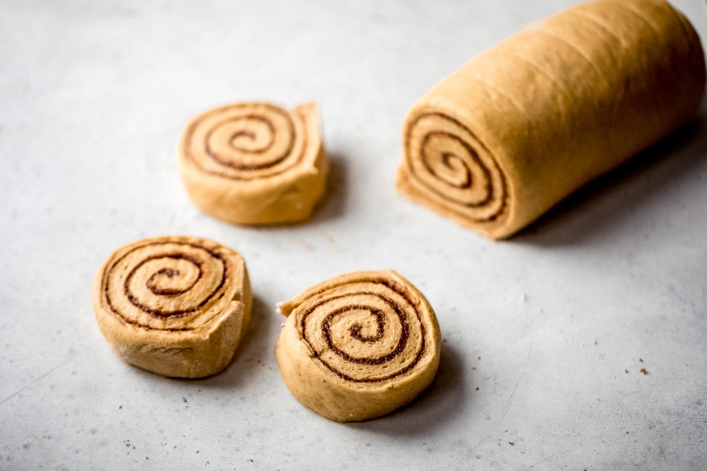 pumpkin cinnamon roll dough being cut