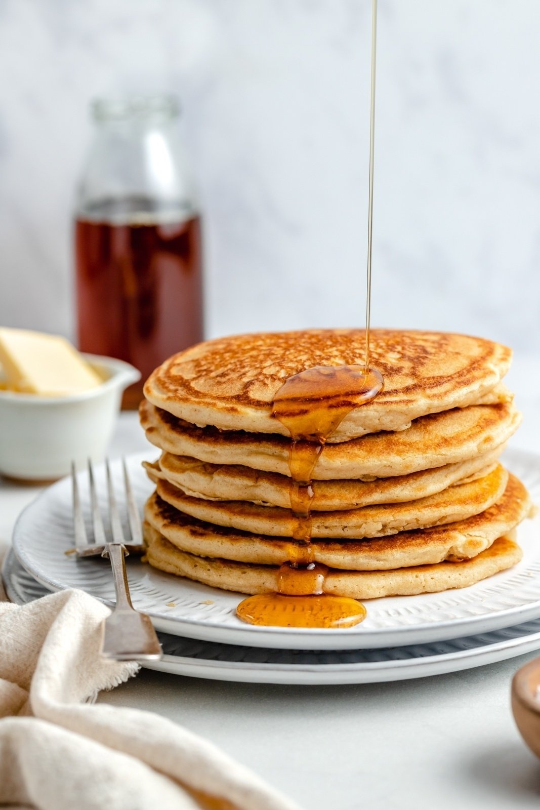 drizzle syrup on a stack of brown butter pancakes