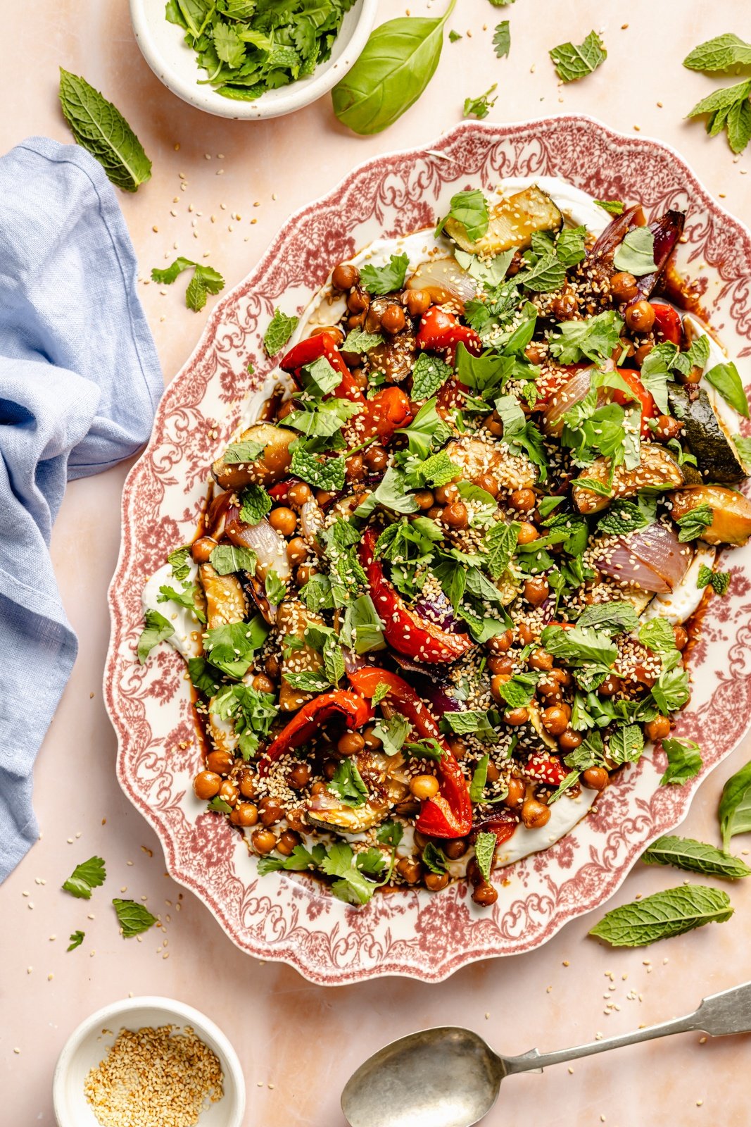 sesame roasted vegetables and chickpea on a platter with tahini garlic yogurt sauce