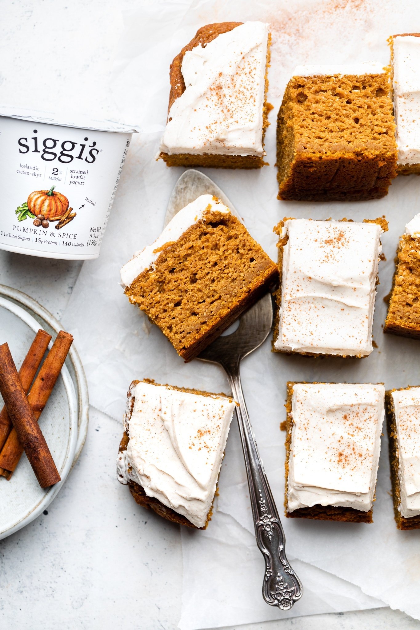 sliced gluten free pumpkin cake next to a container of pumpkin yogurt