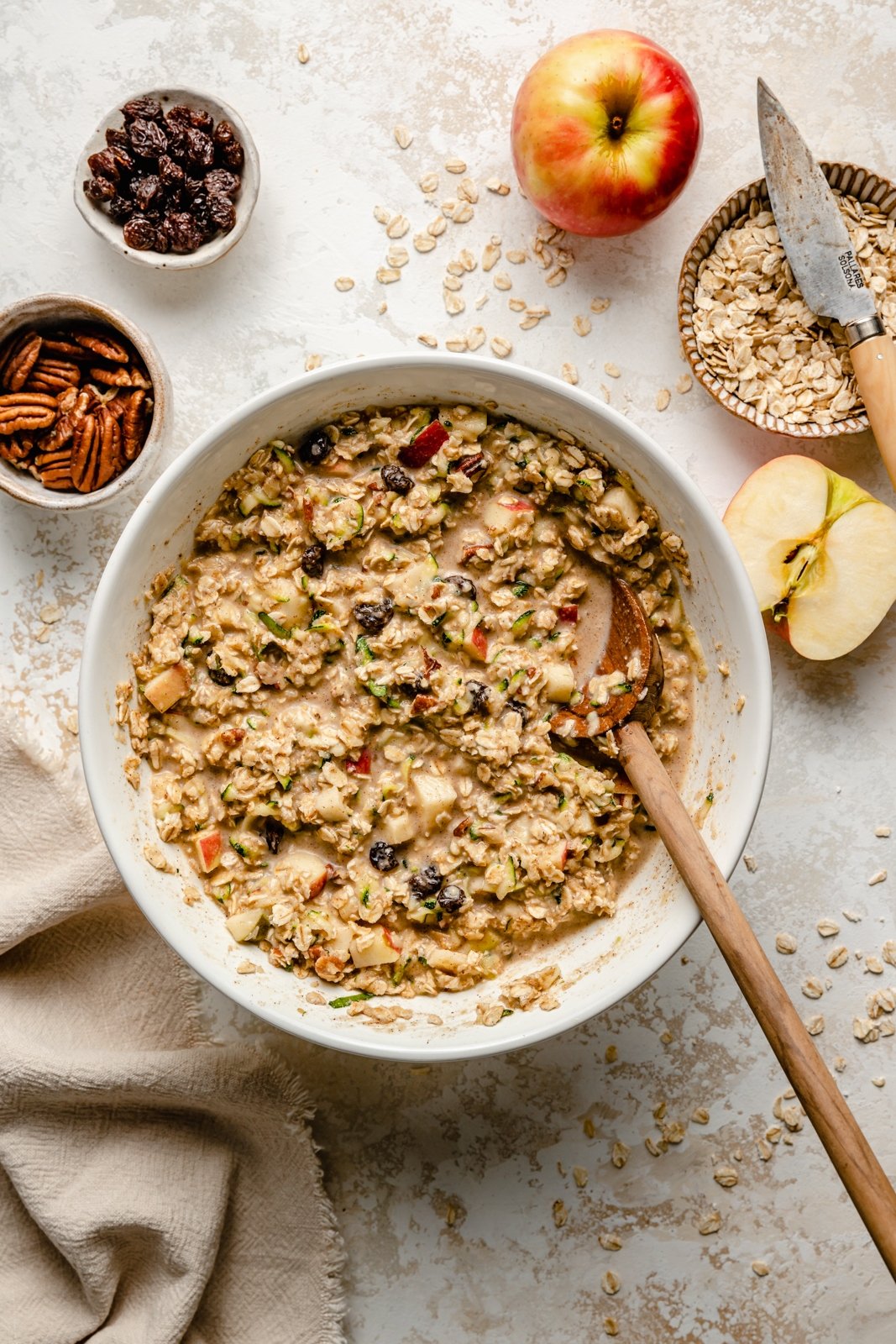 mixing ingredients for an apple zucchini baked oatmeal in a bowl