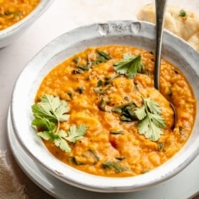 dal in a bowl with a side of naan