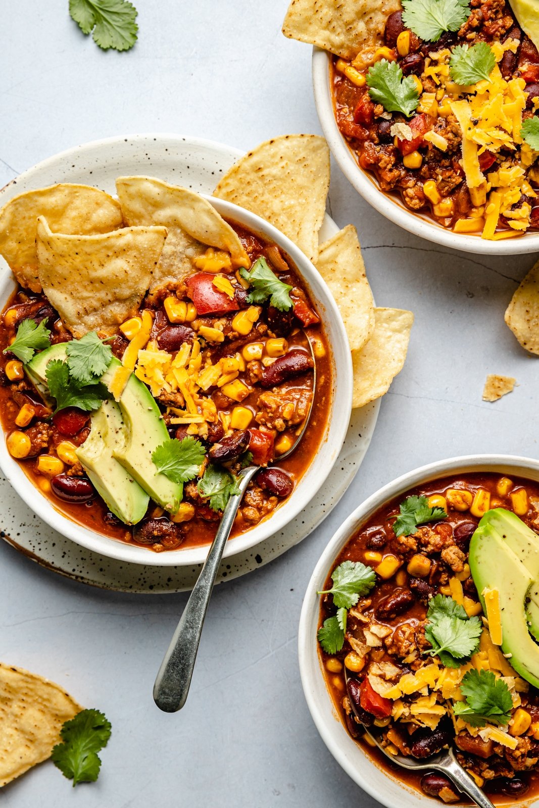 healthy turkey chili in 3 bowls with toppings