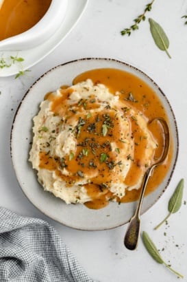 homemade turkey gravy on a plate of mashed potatoes