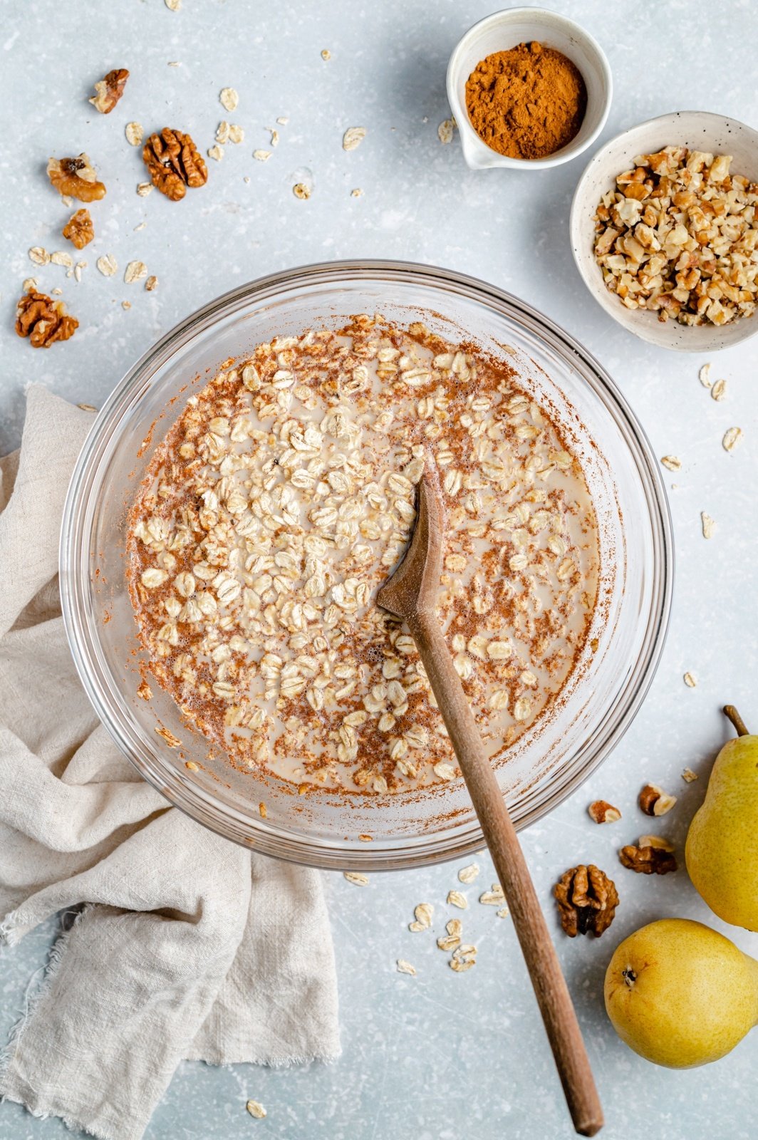 stirring ingredients for pear baked oatmeal in a bowl