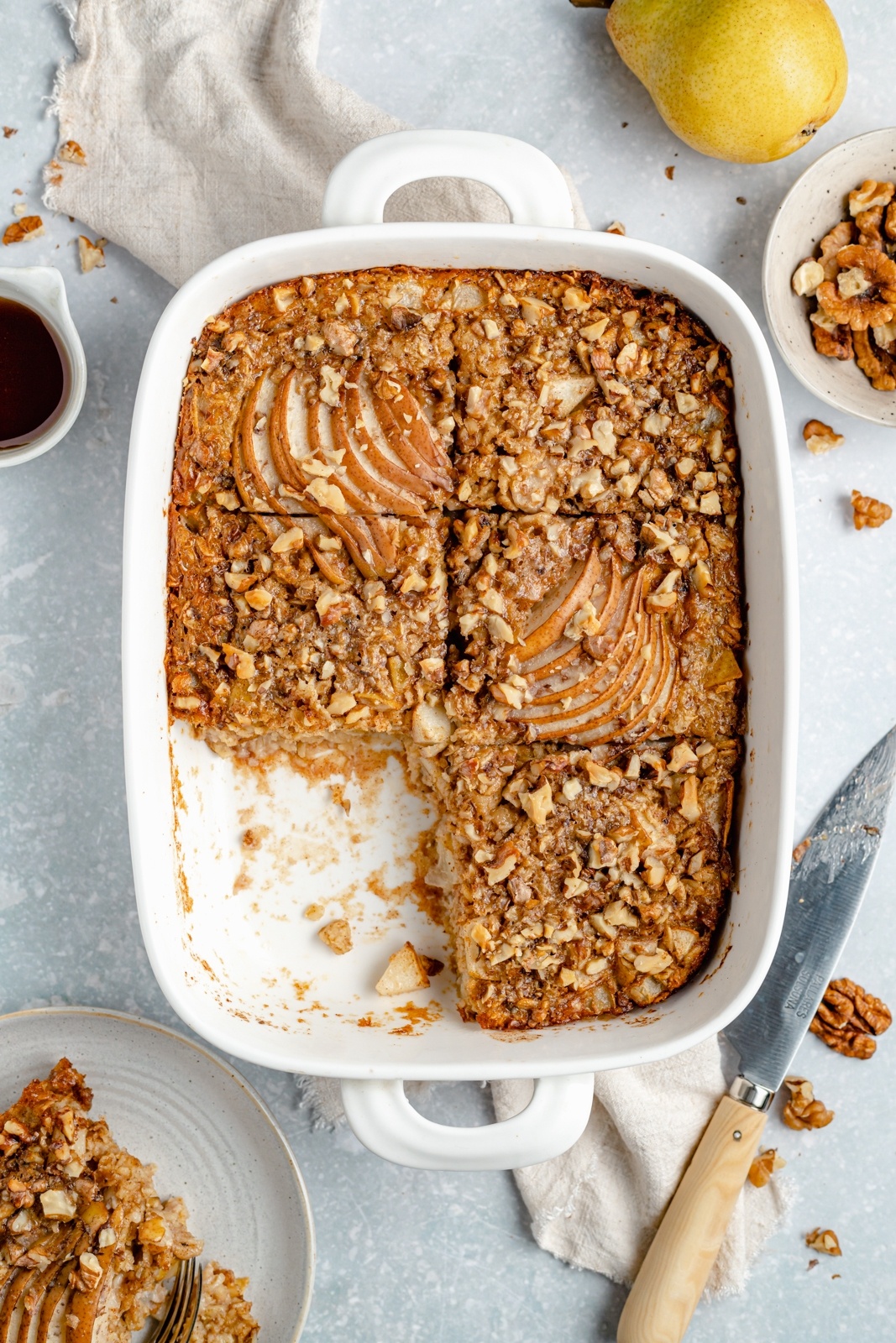 pear baked oatmeal with a slice cut out in a baking dish