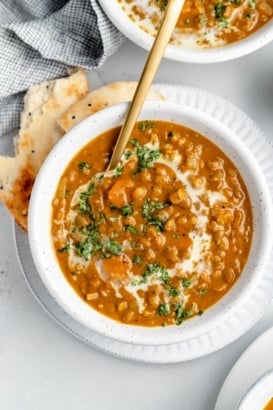 vegan pumpkin lentil soup in a bowl with naan