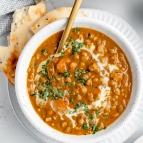 vegan pumpkin lentil soup in a bowl with naan