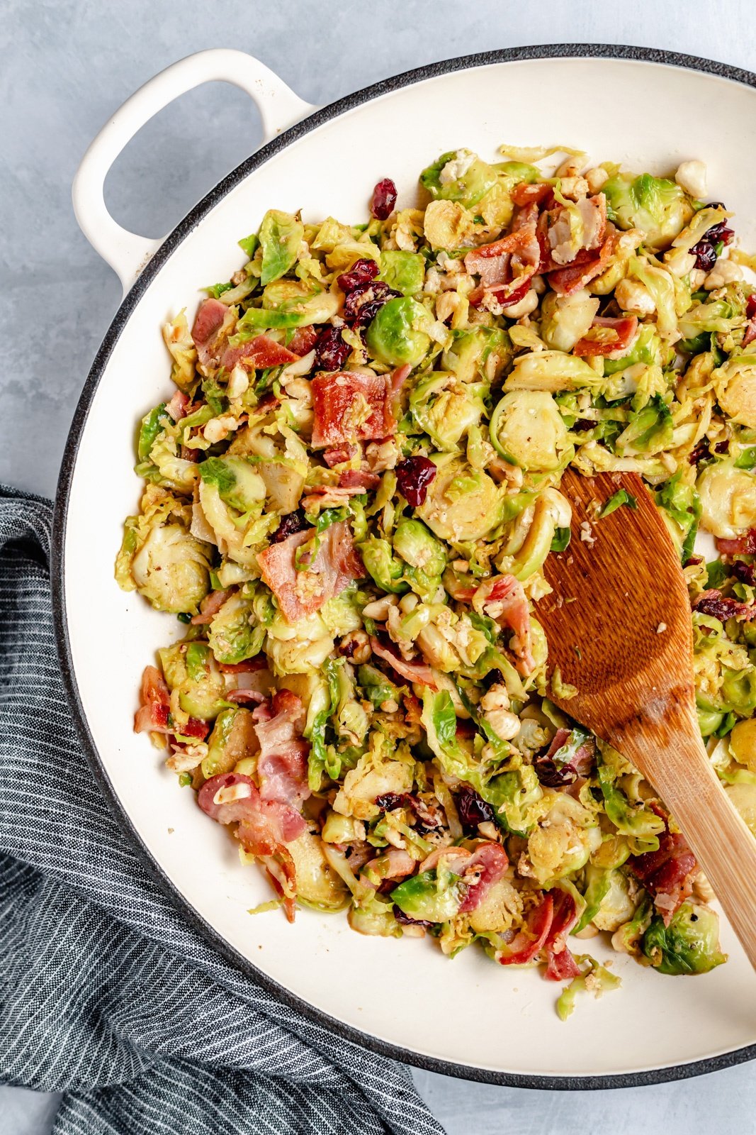 warm brussels salad in a skillet with a wooden spoon