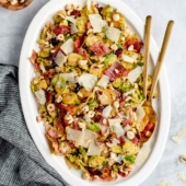 warm brussels sprouts salad with bacon on a platter with serving utensils