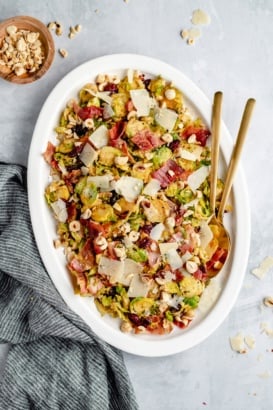 warm brussels sprouts salad with bacon on a platter with serving utensils